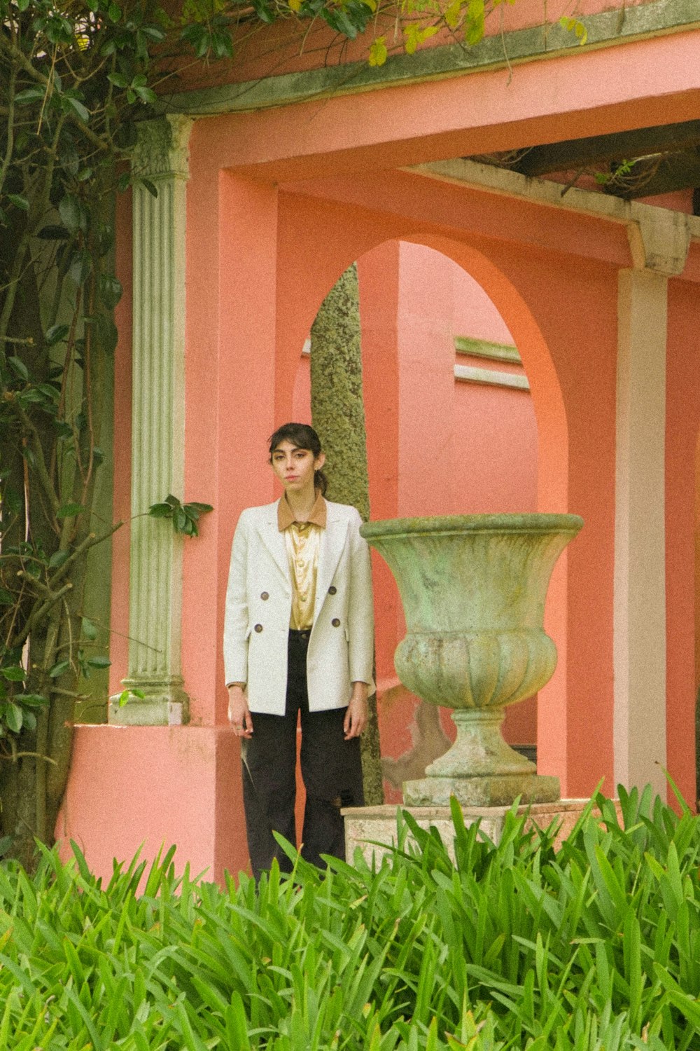 a woman standing in front of a pink building