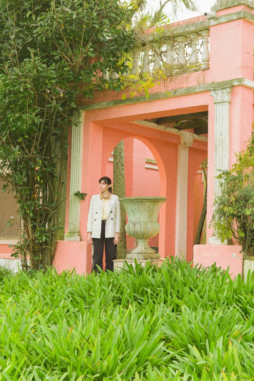 a man standing in front of a pink building