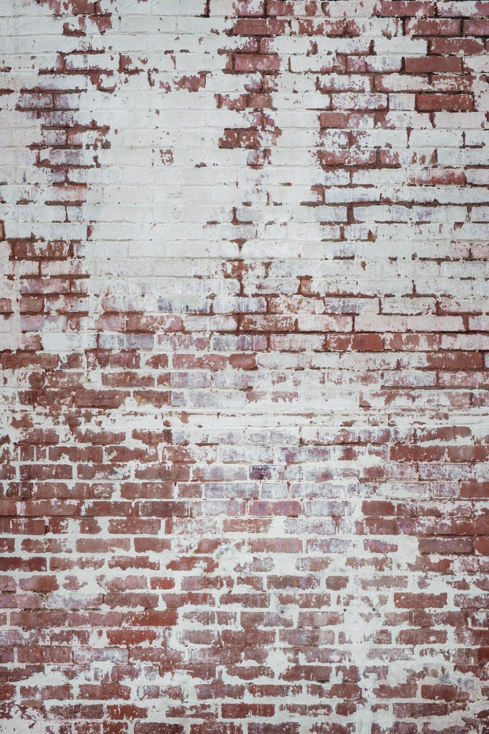 a red brick wall with white paint on it