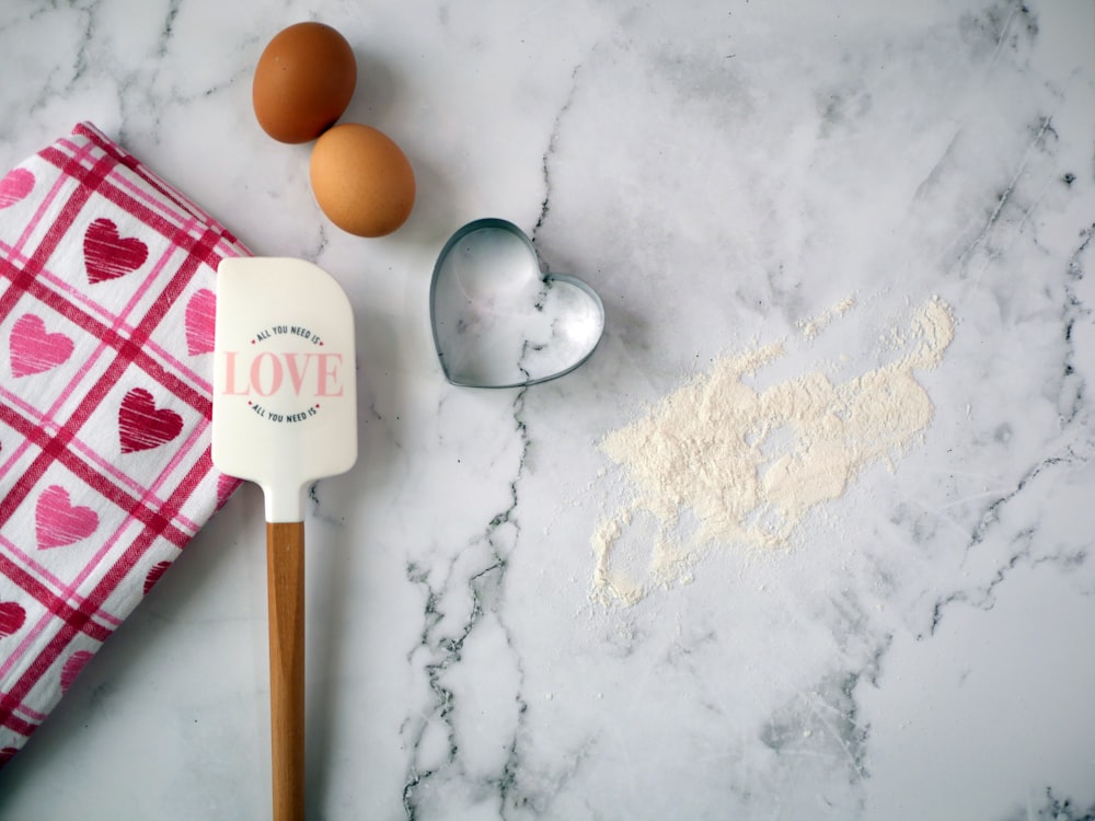 a kitchen counter with a spatula, eggs and flour on it
