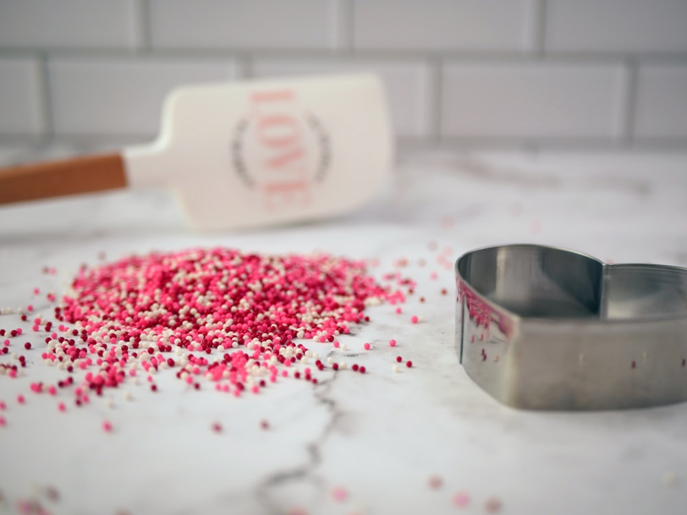 a cookie cutter and a bowl of sprinkles on a counter