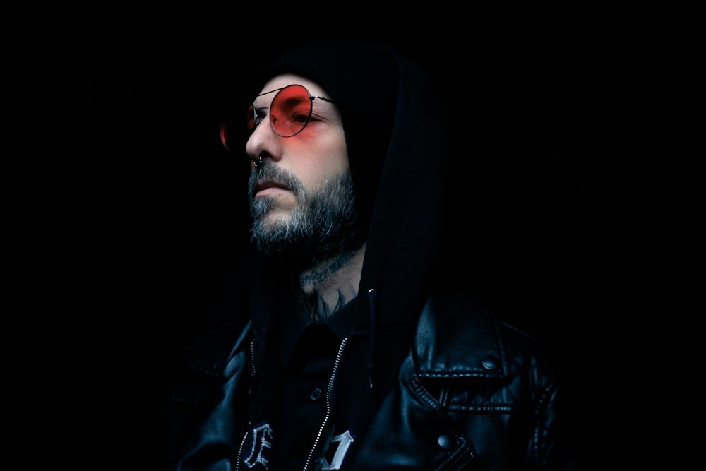 a man with red glasses and a hoodie