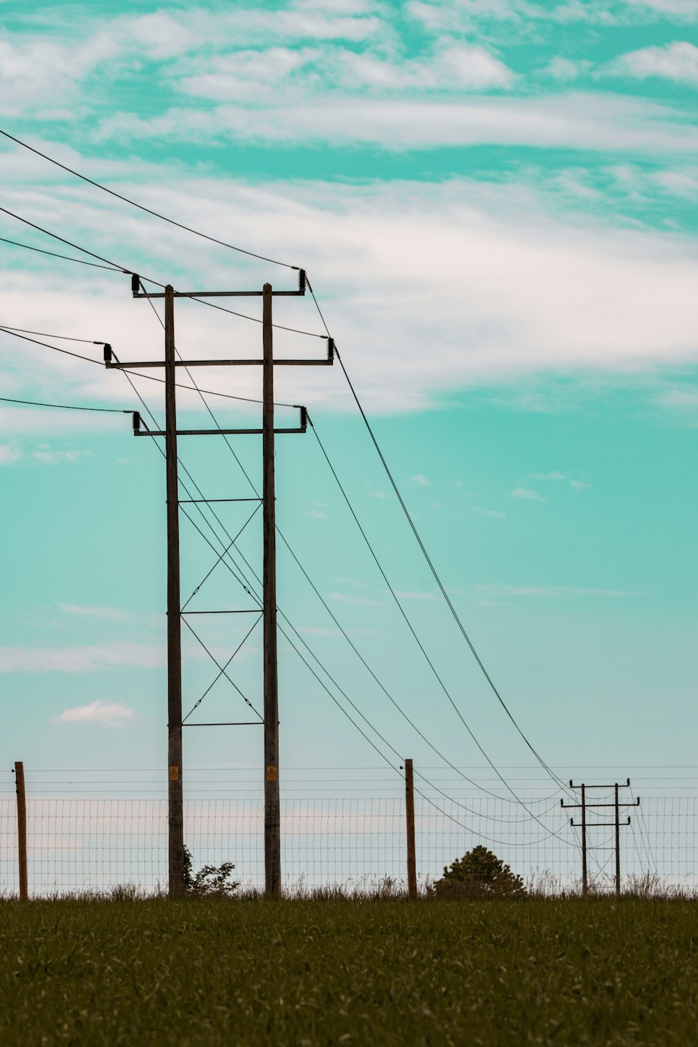 a field with power lines and telephone poles