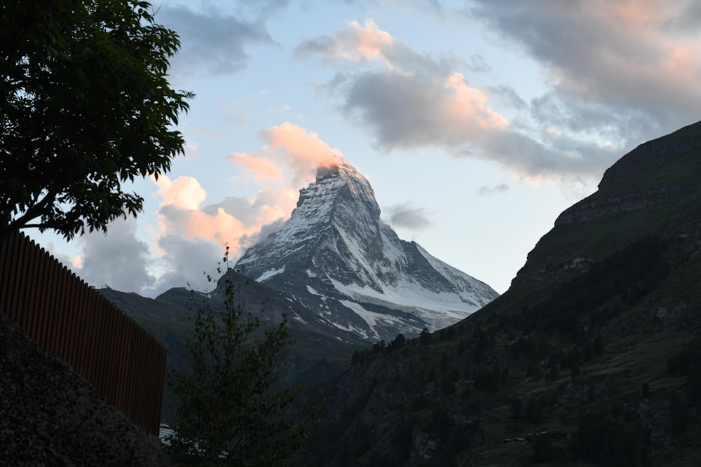 a snow covered mountain in the distance with clouds in the sky