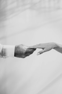 A sleek black and white photo of a confident professional shaking hands with a health influencer in a bright studio.