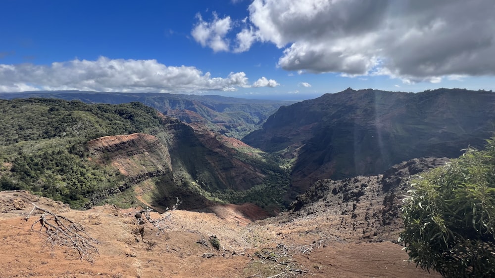 a scenic view of a valley with mountains in the background