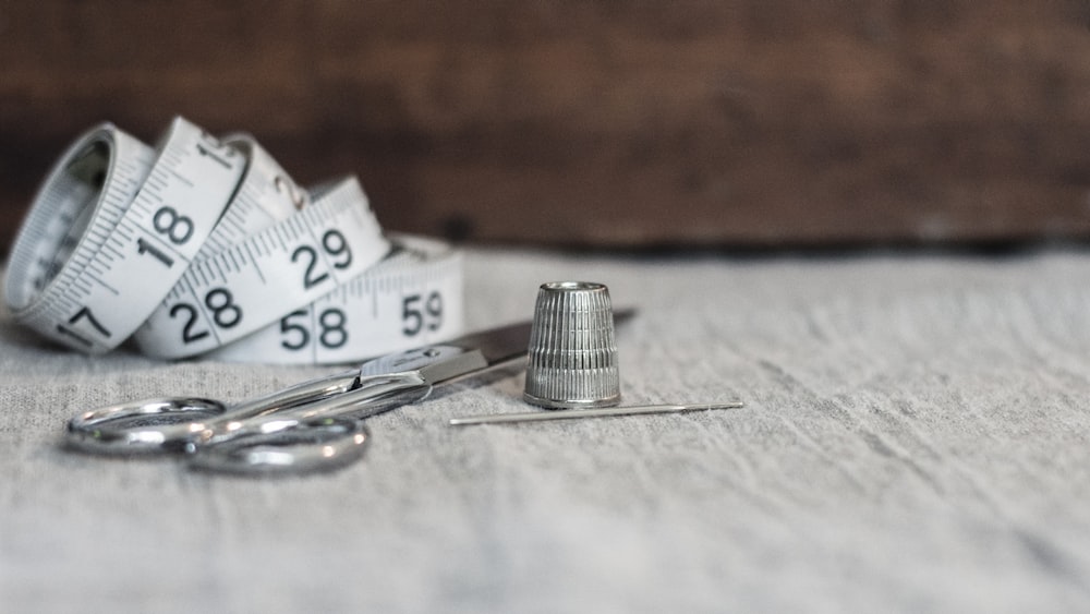 a pair of scissors and a measuring tape on a table