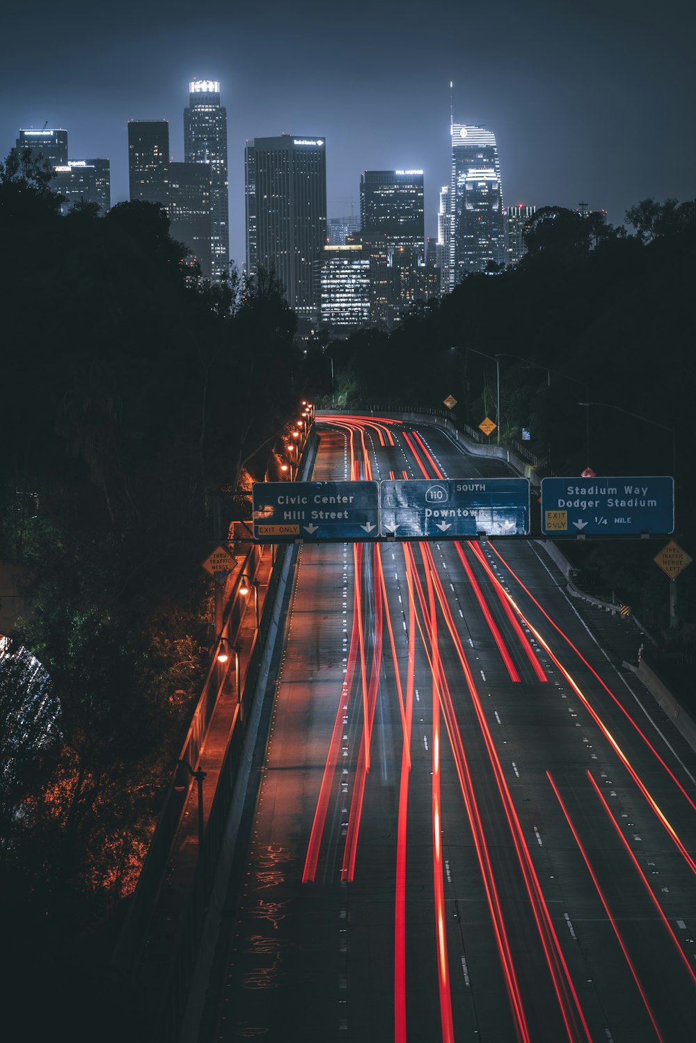 a city skyline at night with long exposure of traffic