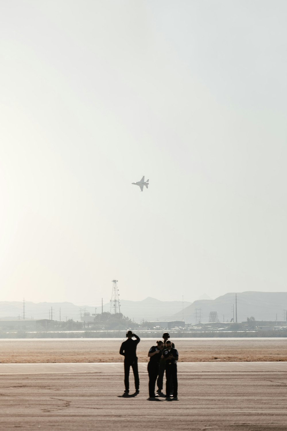 a group of people standing on top of an airport tarmac