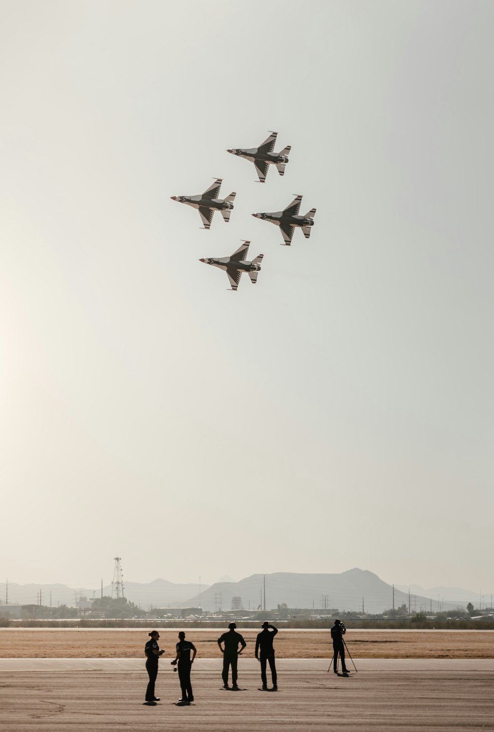 a group of men standing on top of an airport tarmac