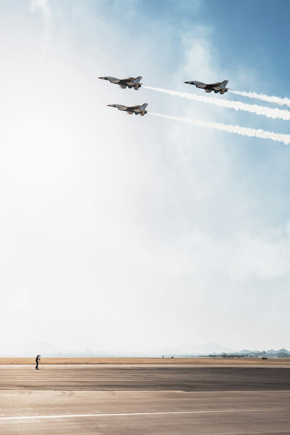 a group of fighter jets flying through a blue sky