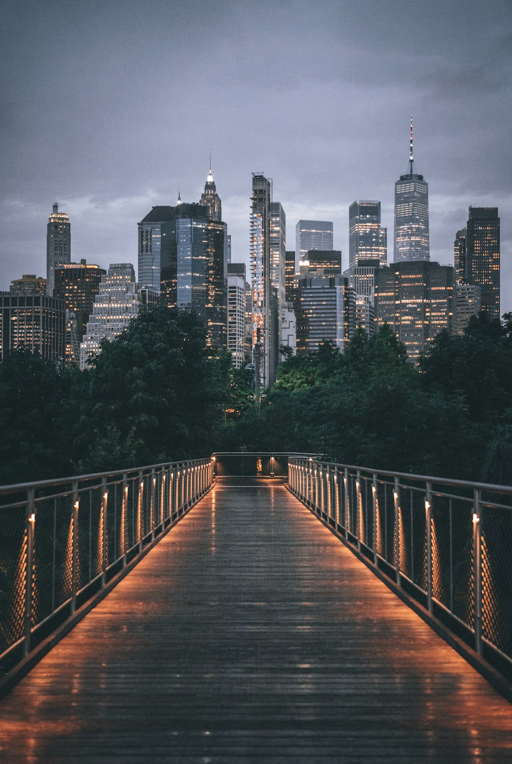 a wooden bridge with a city skyline in the background