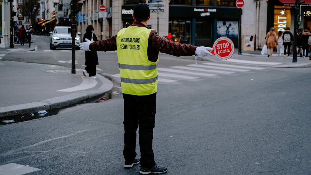 a man in a safety vest holding a stop sign