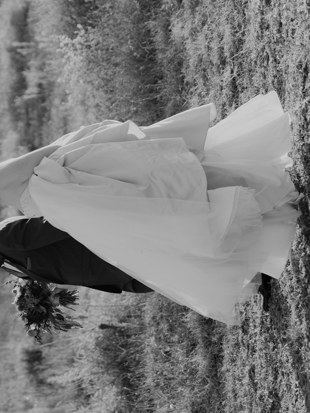 a black and white photo of a bride holding an umbrella