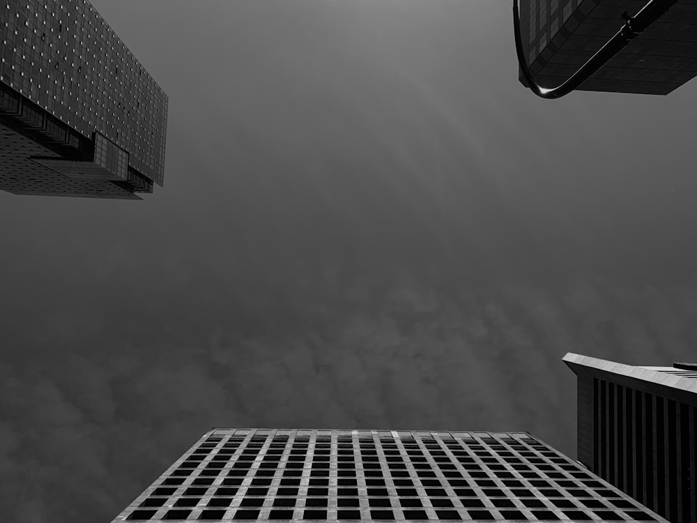 a black and white photo of skyscrapers against a cloudy sky