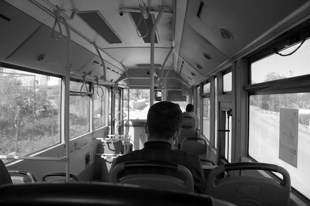 a black and white photo of people on a bus