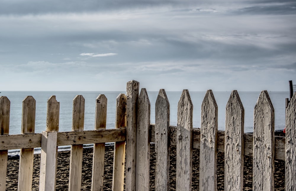 a wooden fence next to a body of water