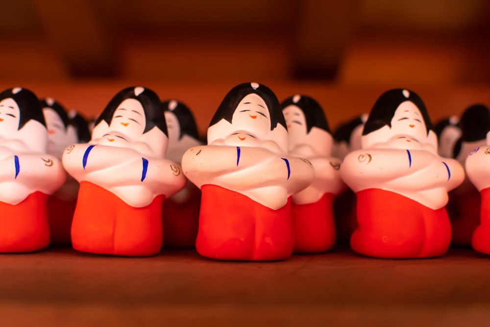 a row of small figurines sitting on top of a wooden table