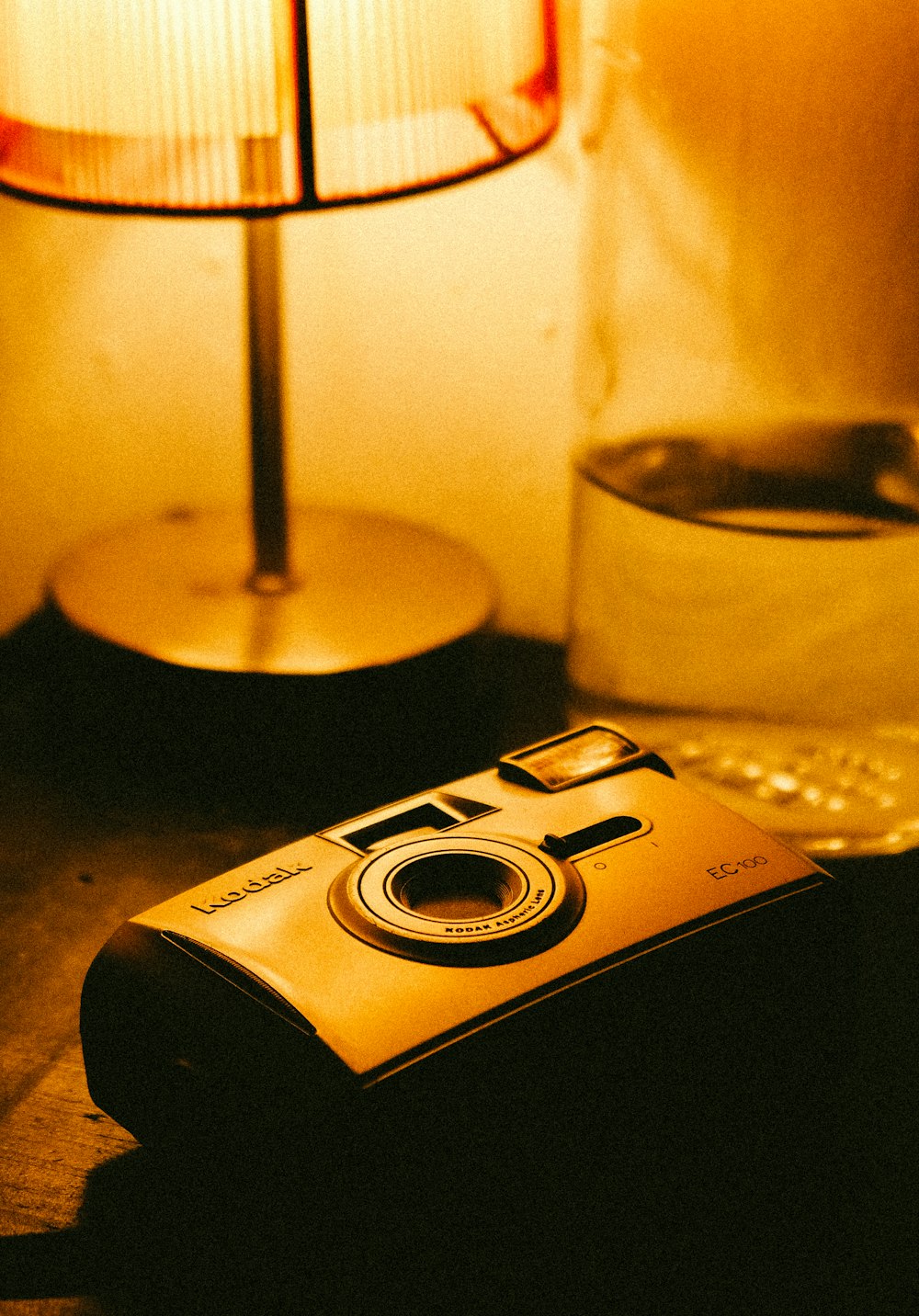 a camera sitting on a table next to a lamp
