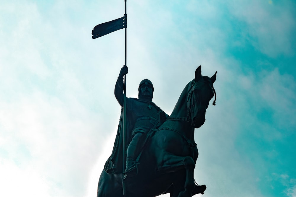 a statue of a man riding a horse holding a flag