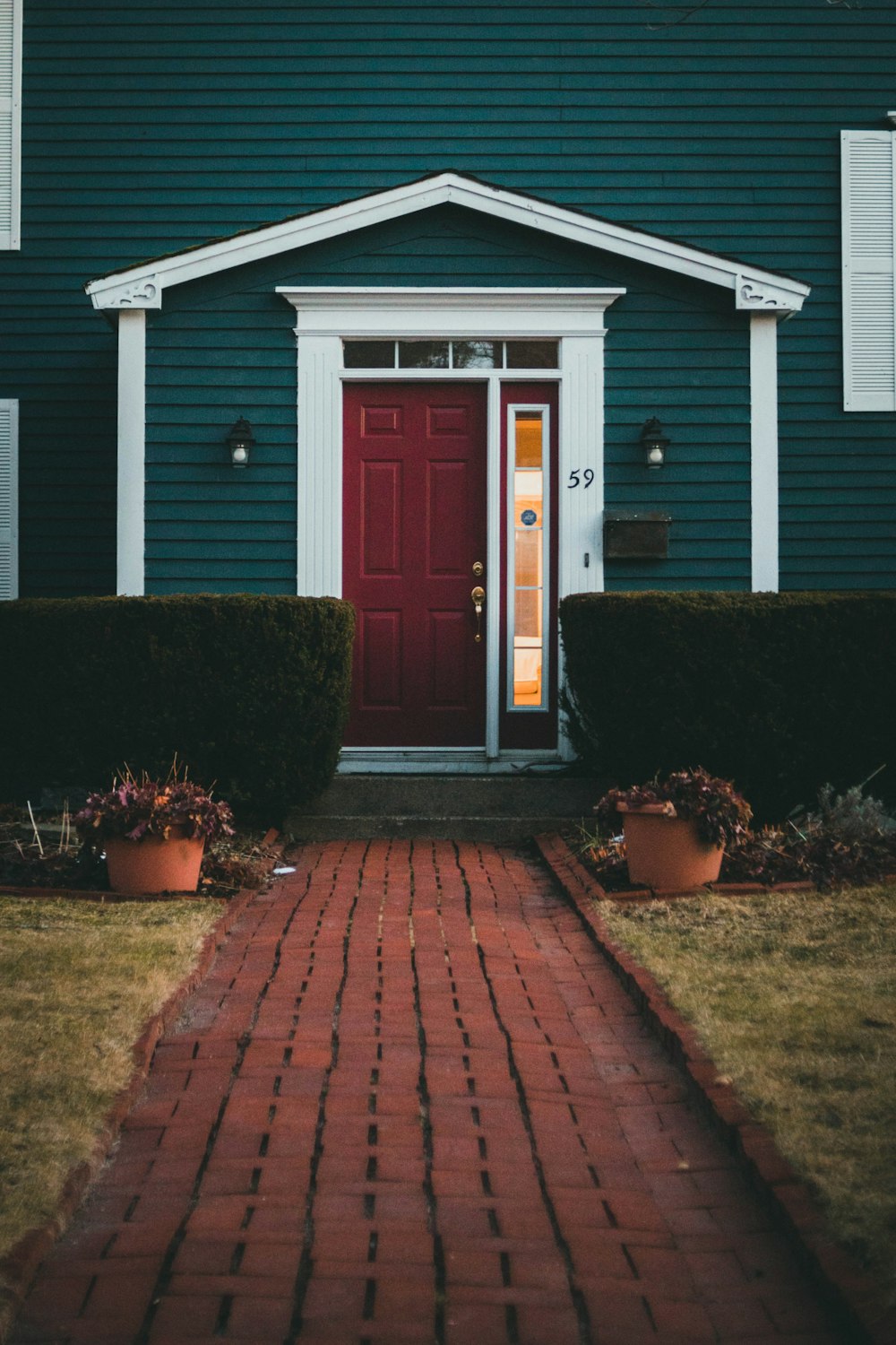 a house with a red door and a red brick walkway