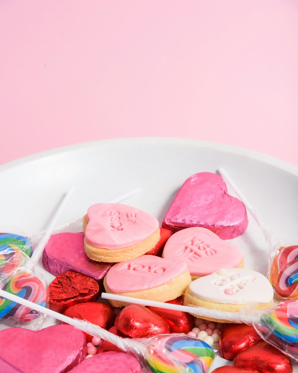 a white bowl filled with lots of heart shaped cookies