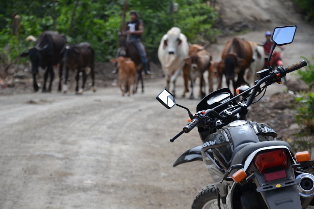 a motorcycle parked on the side of a dirt road