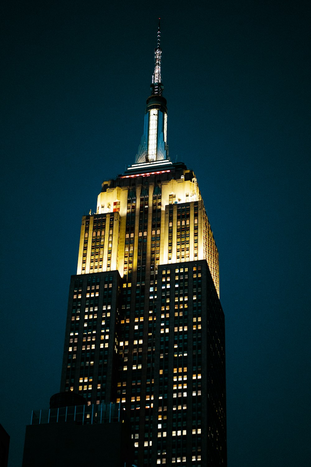 o topo de um edifício alto iluminado à noite