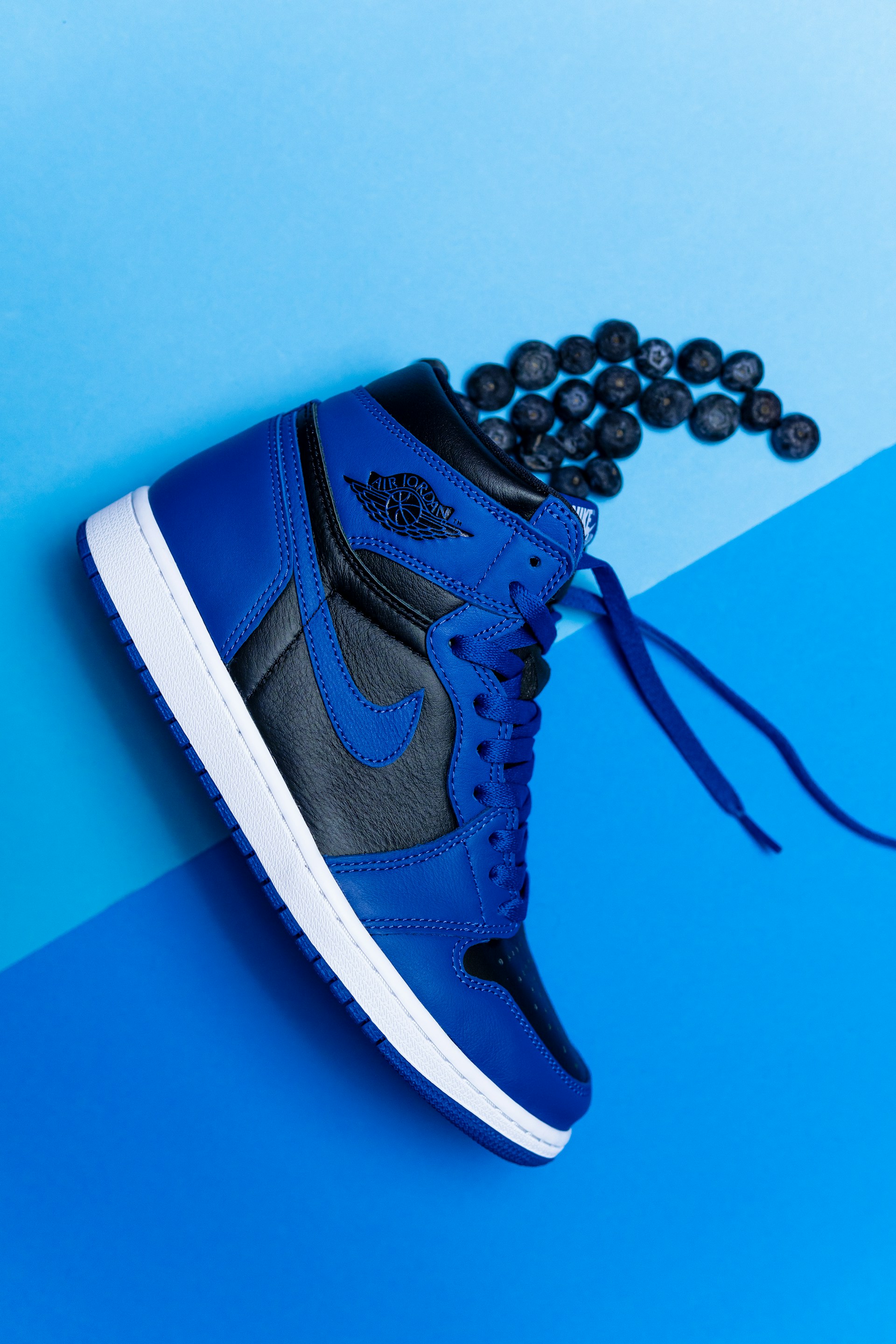 a pair of blue and black sneakers on a blue and blue background