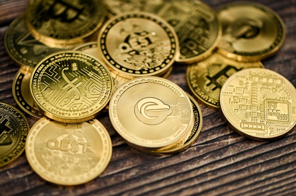 a pile of gold coins sitting on top of a wooden table