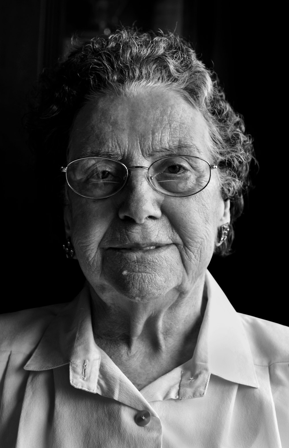 a black and white photo of a woman wearing glasses