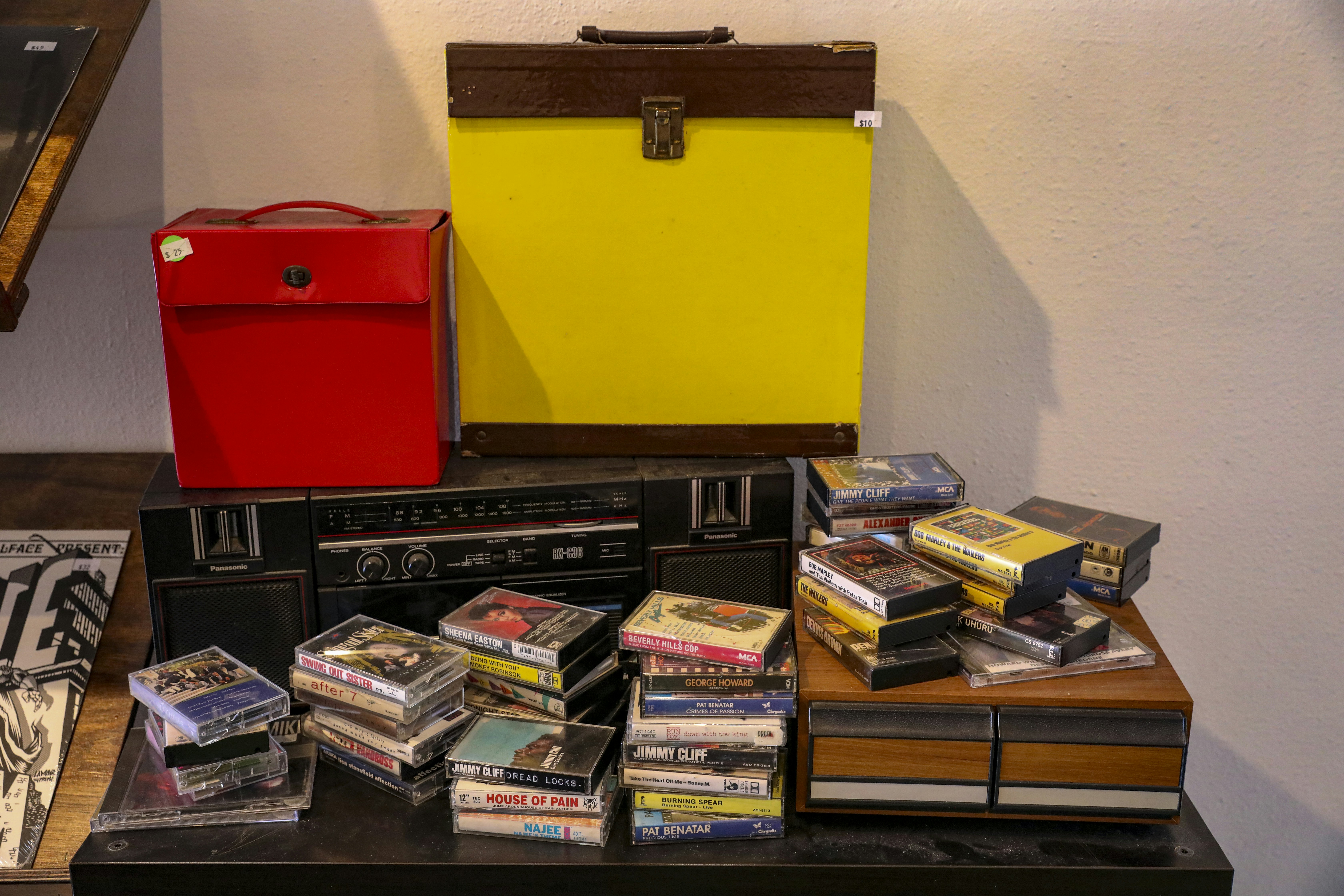 Boombox Panasonic antiguo con casetes y cajas de almacenamiento.