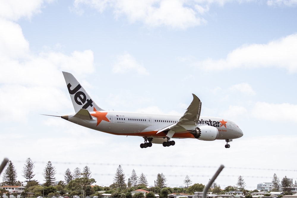 a large jetliner flying through a blue cloudy sky