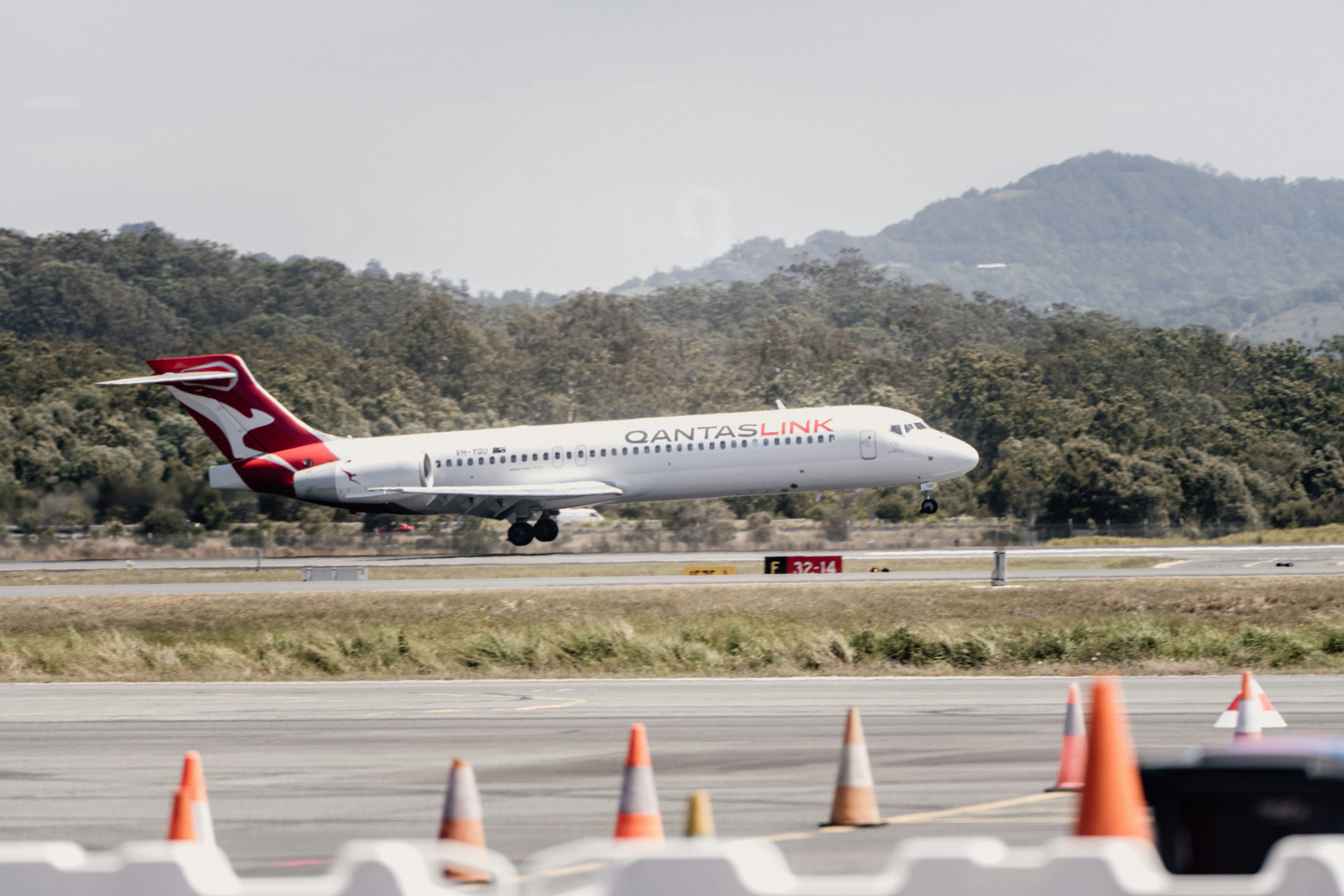 a large jetliner taking off from an airport runway, Gold Coast Airport by Josh Withers