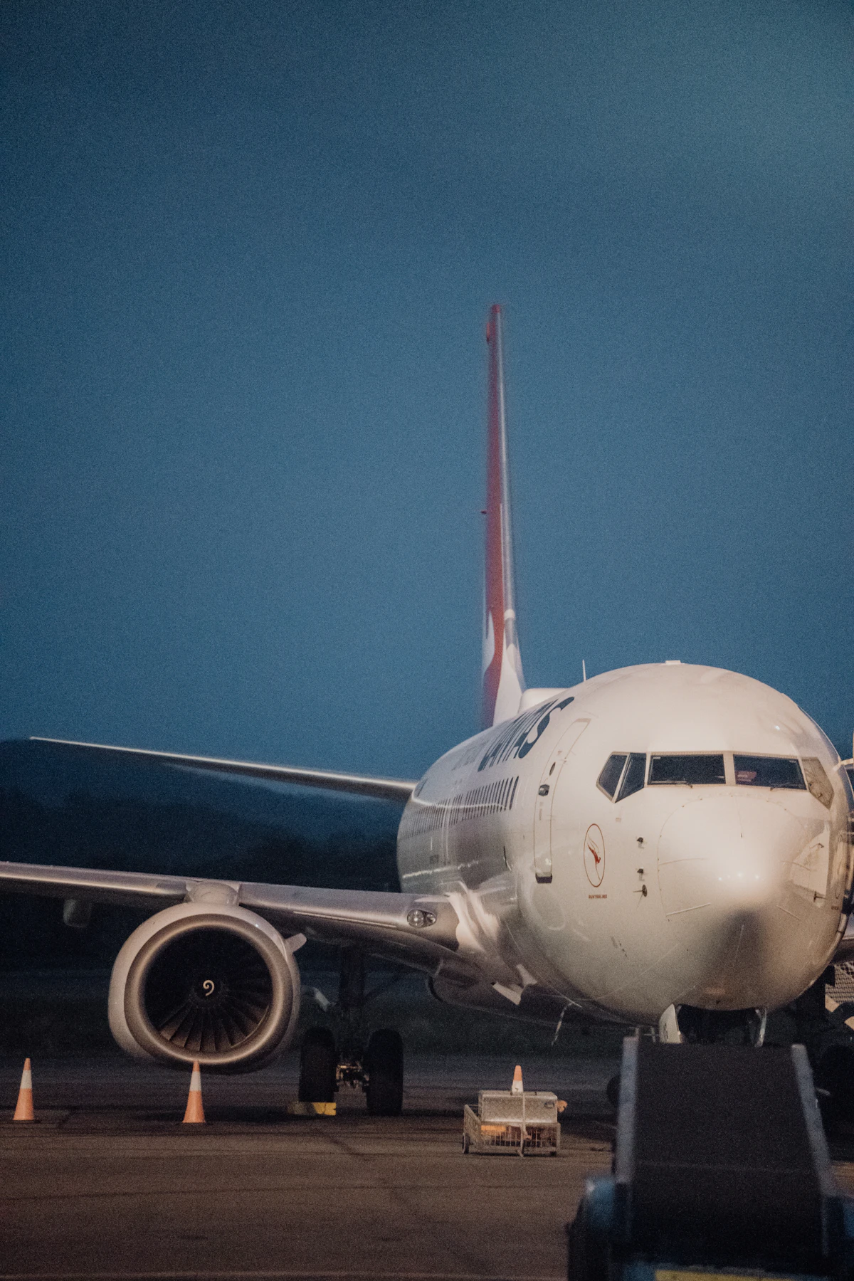 A narrowbody jet parked on an empty airport apron in evening light