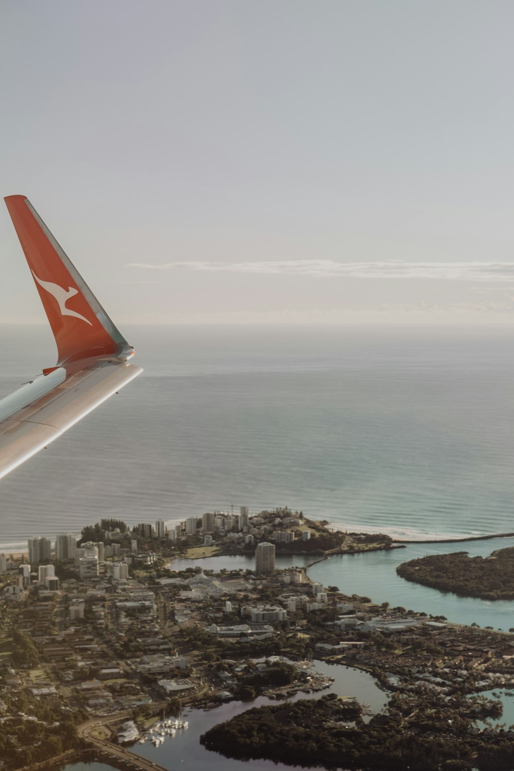 an airplane wing flying over a large body of water