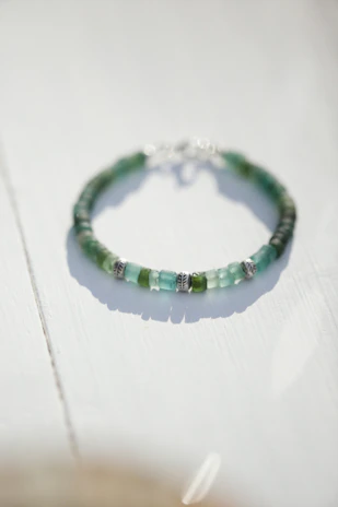 Close-up of elegant blue and white beaded bracelets arranged neatly on a clean white surface with soft natural lighting.