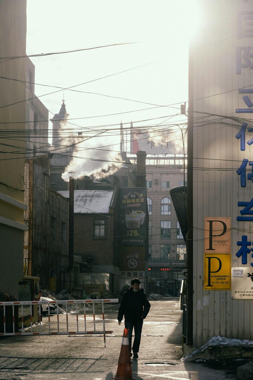 a man walking down a street next to tall buildings