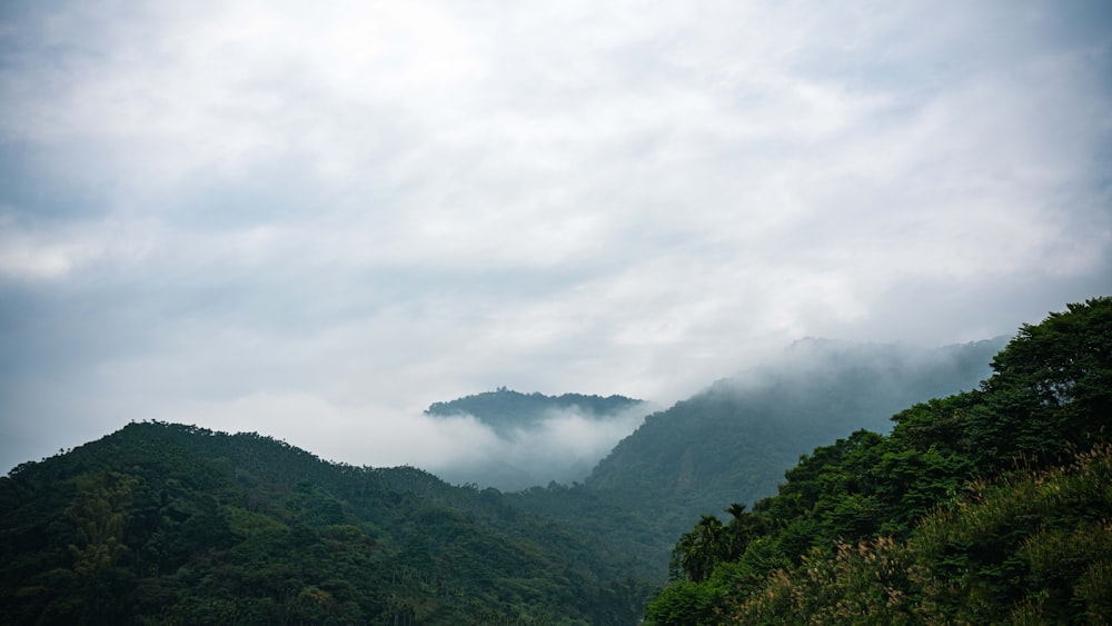 a scenic view of a mountain range with low lying clouds