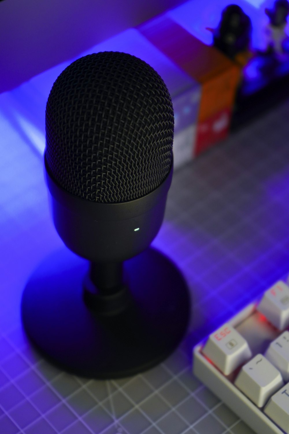ein Mikrofon, das auf einem Tisch neben einer Tastatur sitzt