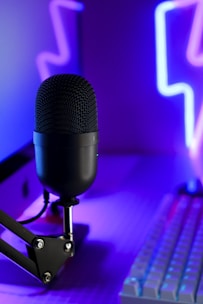 a microphone sitting on top of a desk next to a keyboard