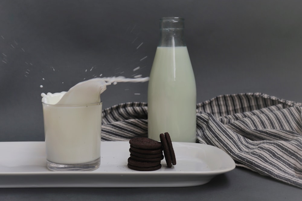 a bottle of milk and a glass of milk on a plate