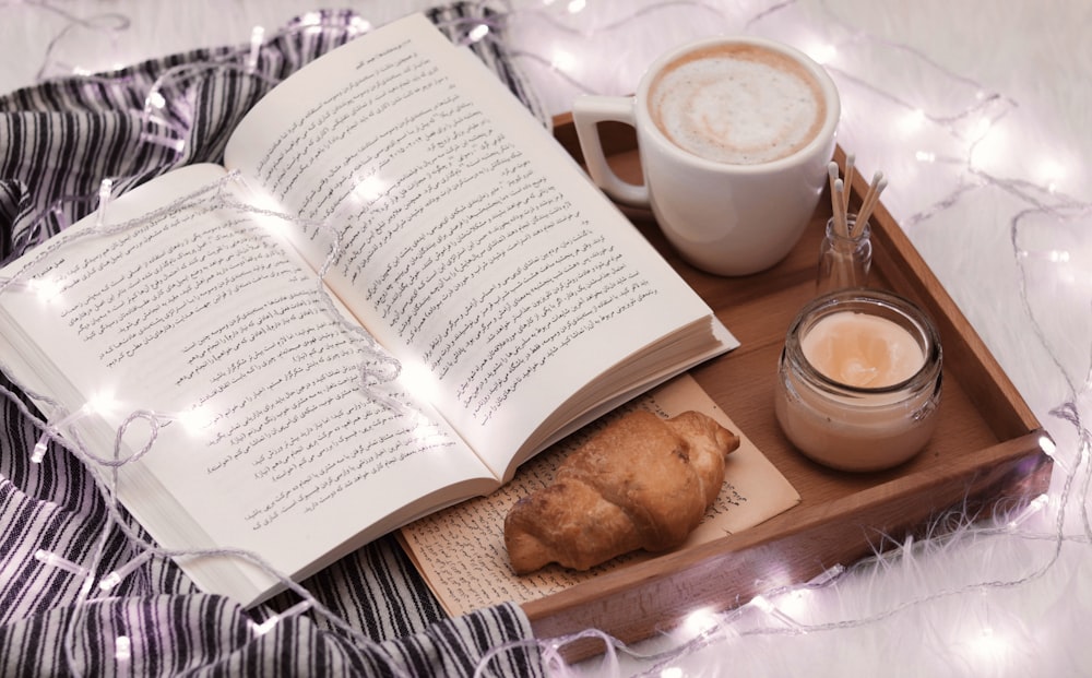 a cup of coffee and a book on a tray