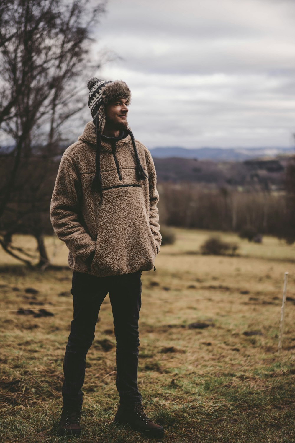 a man standing in a field with a hat on