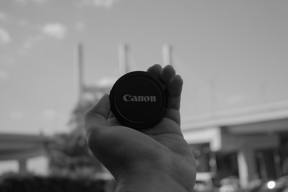 a black and white photo of a person holding a camera