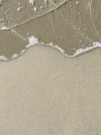 a sandy beach with waves coming in to shore