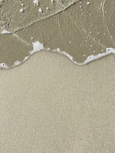 a sandy beach with waves coming in to shore