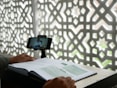 a person sitting at a desk with a book and a cell phone