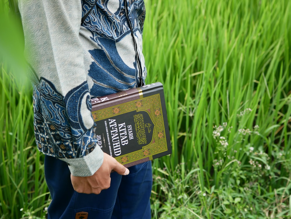 a person holding a bottle of beer in a field
