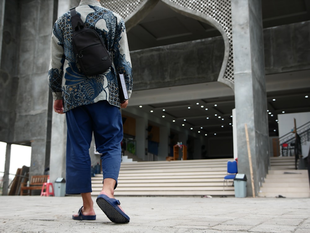 a person with a backpack walking towards a building